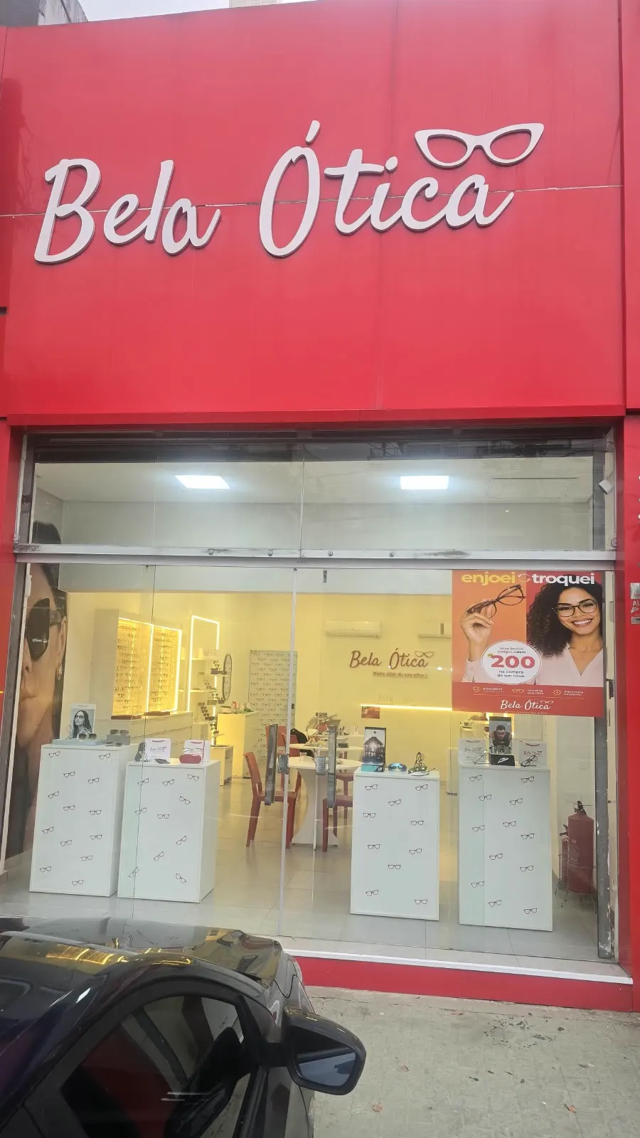 Fachada vermelha da Bela Ótica com o letreiro no Guarujá